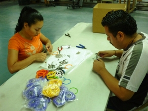 Workers making GivingBands in El Salvador charmed giving program