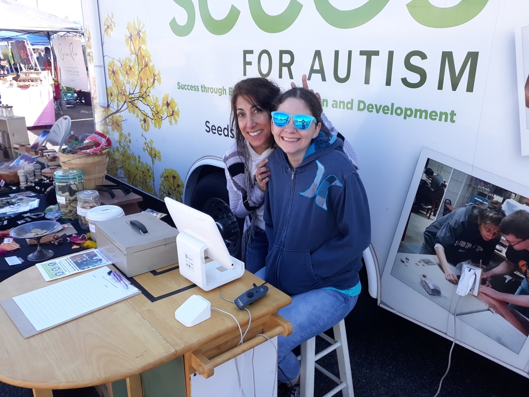 The SEEDs for Autism mobile boutique at a community event in Phoenix, with team members and handmade products.